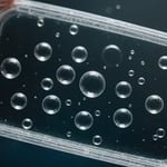 Close-up of plastic part with visible air bubbles, showcasing injection molding defect.