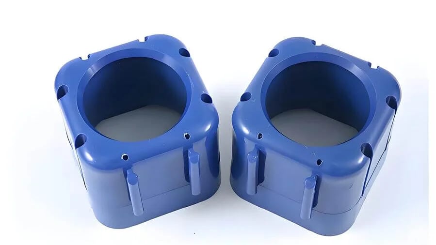 Two blue plastic cube-like objects with rounded edges and cylindrical openings on top