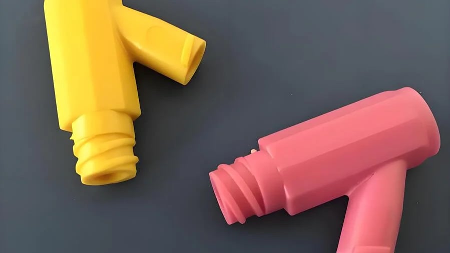 Two colorful plastic nozzles, one yellow and one pink, on a dark gray background.