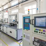 A high-tech injection molding workshop with advanced machinery and a technician adjusting controls.