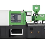 An industrial injection molding machine with green and black components showcasing its robust structure.