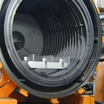 Interior view of a large industrial vacuum chamber with concentric grooves and metallic components.