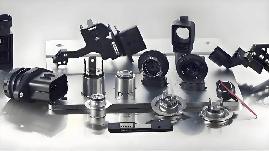 A collection of automotive and electronic mechanical components arranged on a reflective surface.