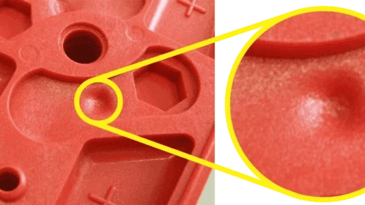 Close-up of molded plastic parts showing shrinkage marks