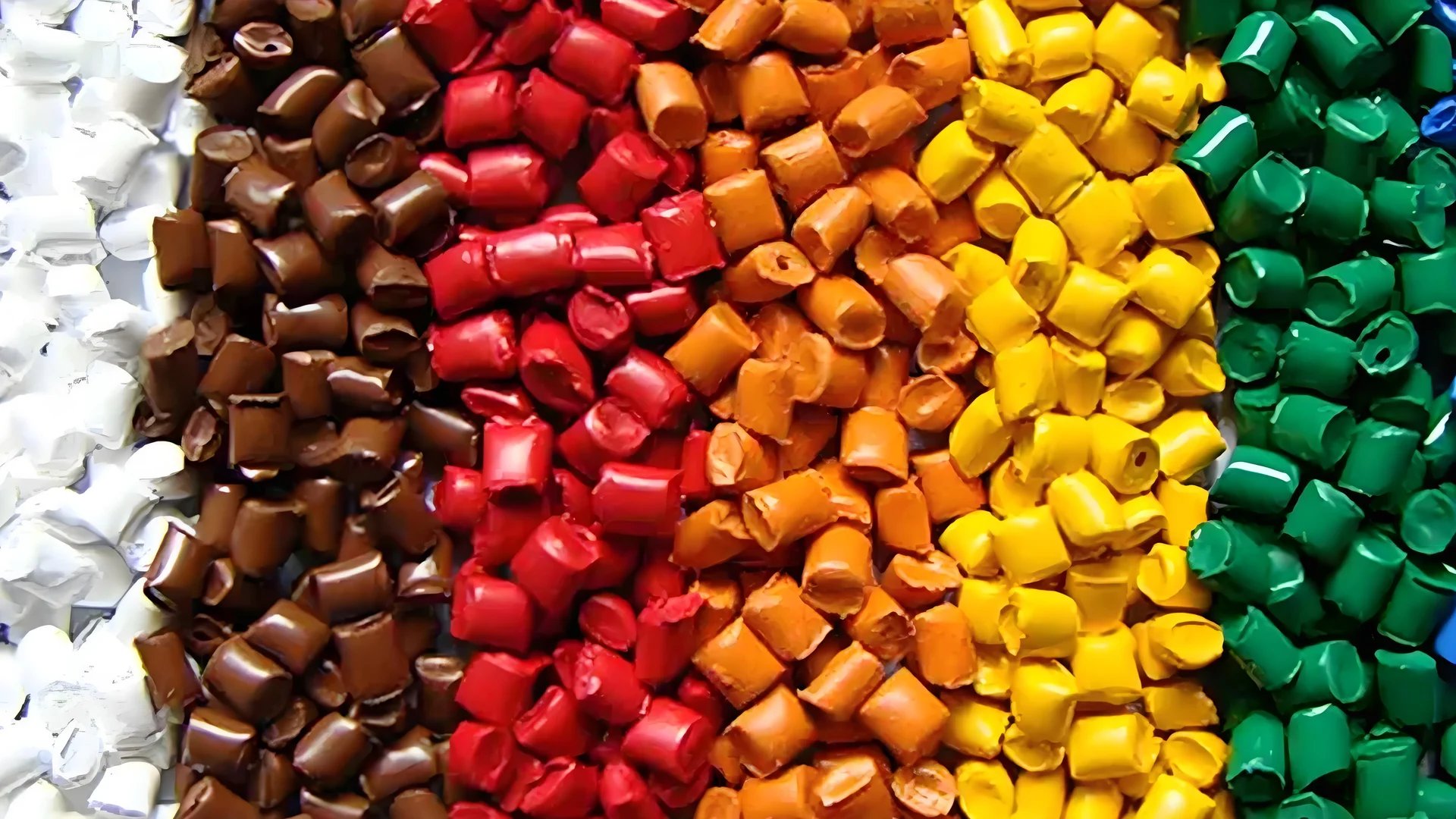 Close-up of various plastic materials used in injection molding, showcasing different textures and colors.