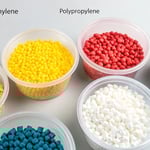 Colorful plastic pellets on a neutral background