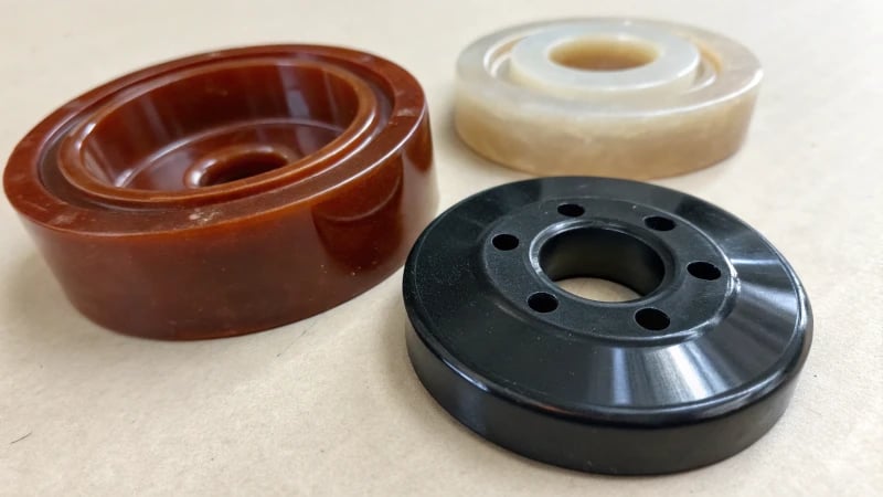 Three injection molded samples on a neutral background